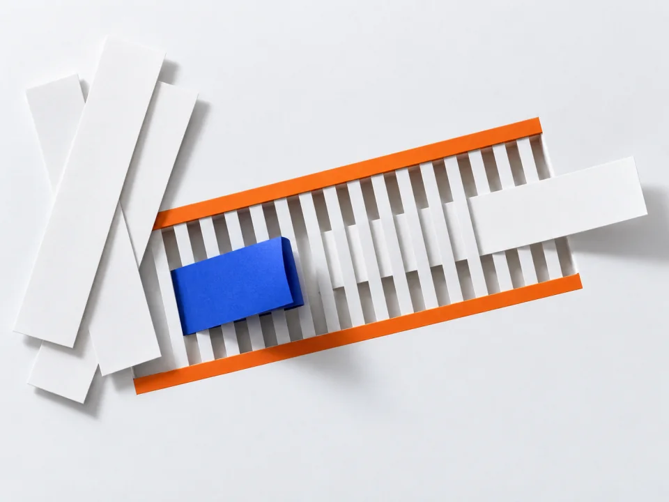 Paper slips at a slotted paper grille; a cobalt sleeve left behind at the slits.