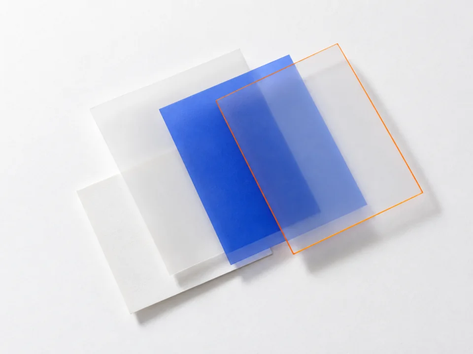 Three overlapping translucent sheets: a white layer, a cobalt layer and one outlined in orange.
